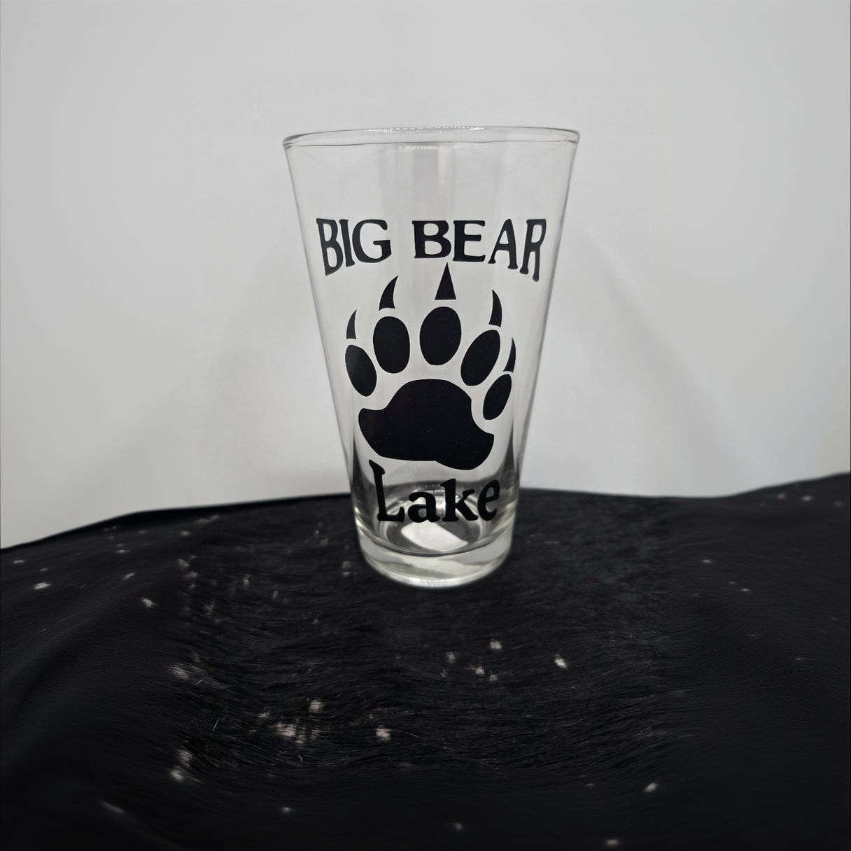 assorted Big Bear California themed pint beer glasses featuring bear paw mountain and forest logo designs for rustic cabin and lodge drinkware