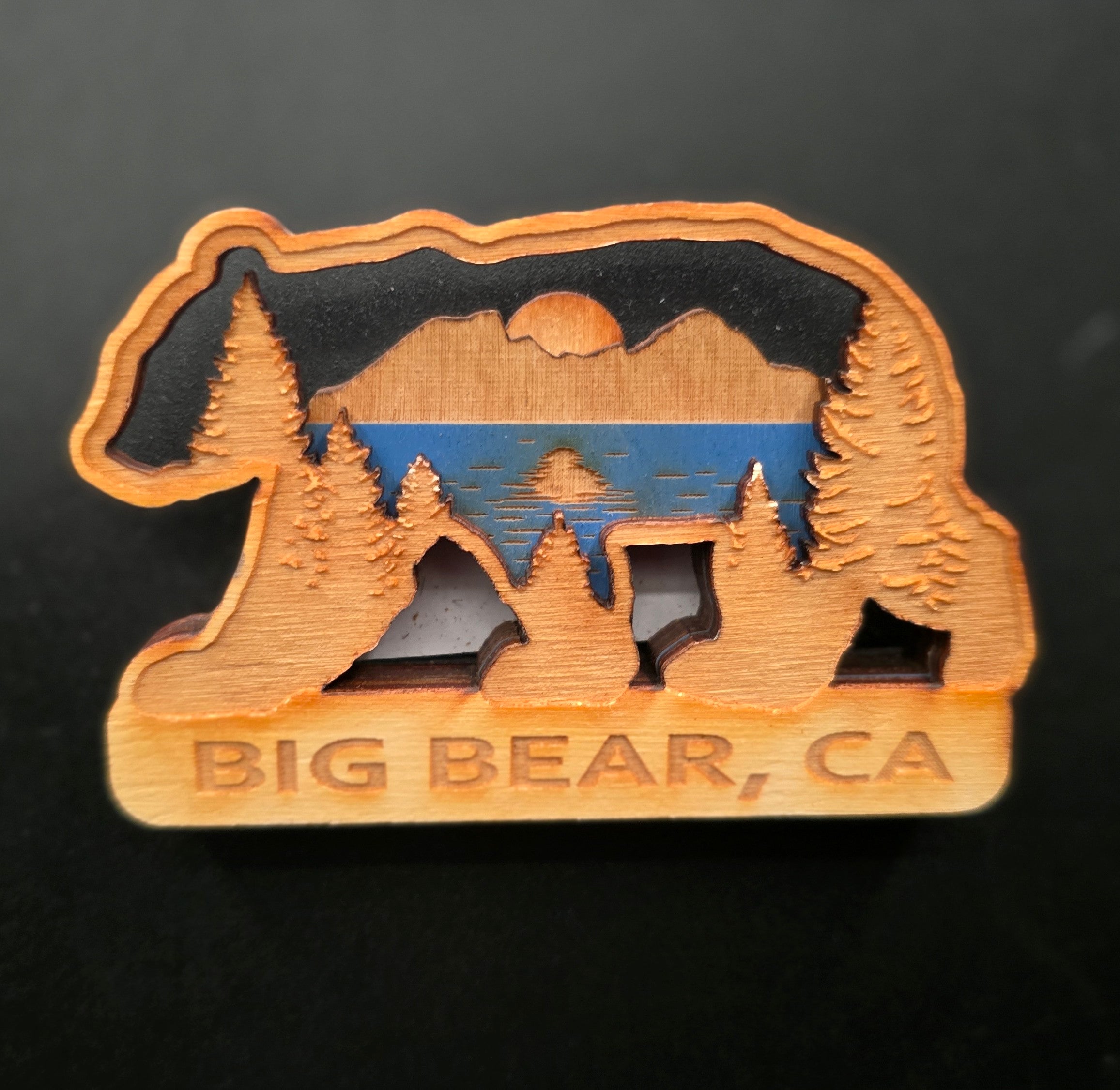 3d laser cut wooden big bear ca magnet featuring layered bear silhouette with mountain lake and pine tree scene measuring 3.5 by 2.25 inches
