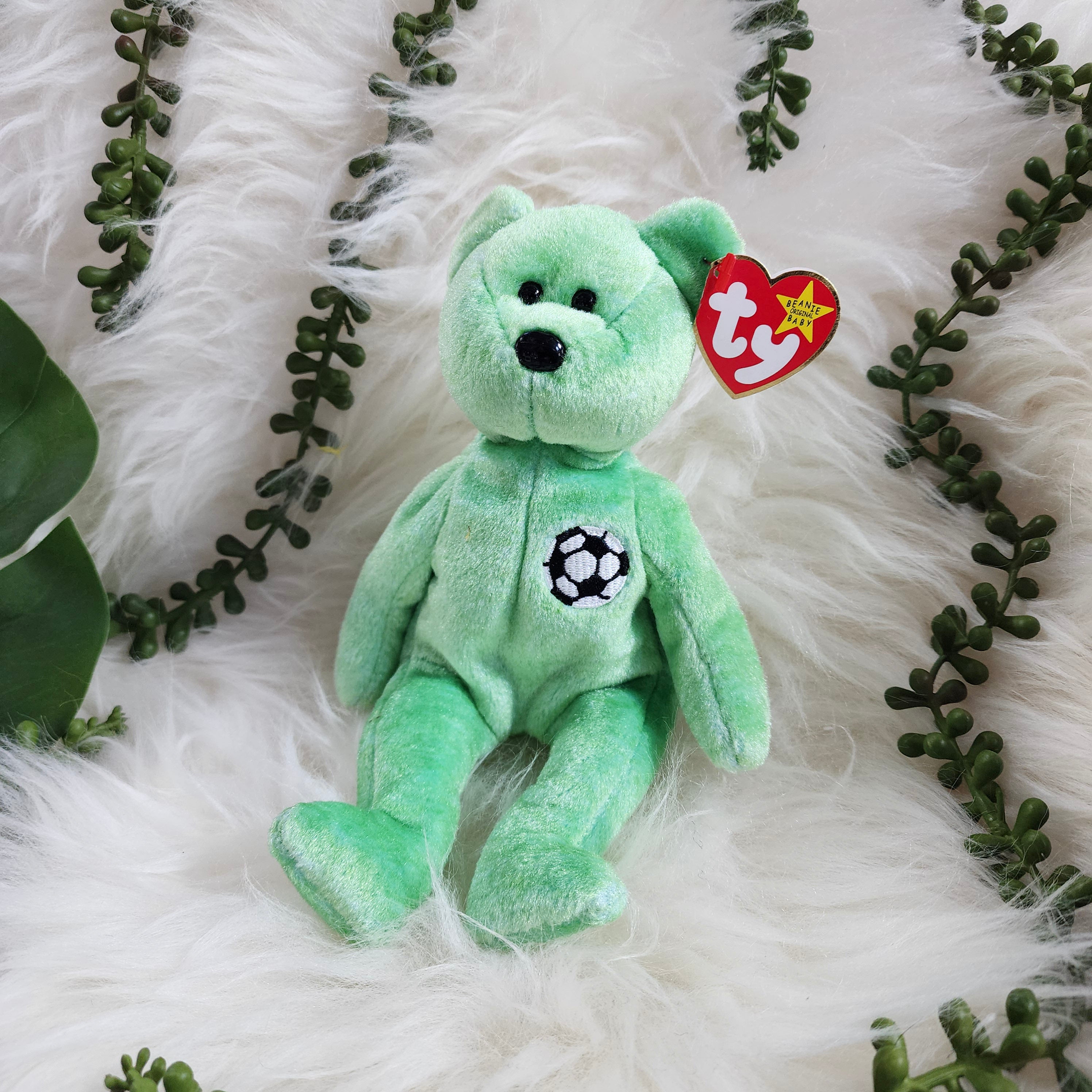 Ty Beanie Babies 'Kicks the Bear' plush toy in green with a soccer ball pattern on its chest