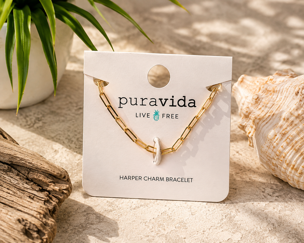 Pura Vida Harper Charm Bracelet displayed on the original branded card featuring a polished gold paperclip chain with a minimalist charm and secure retail packaging.