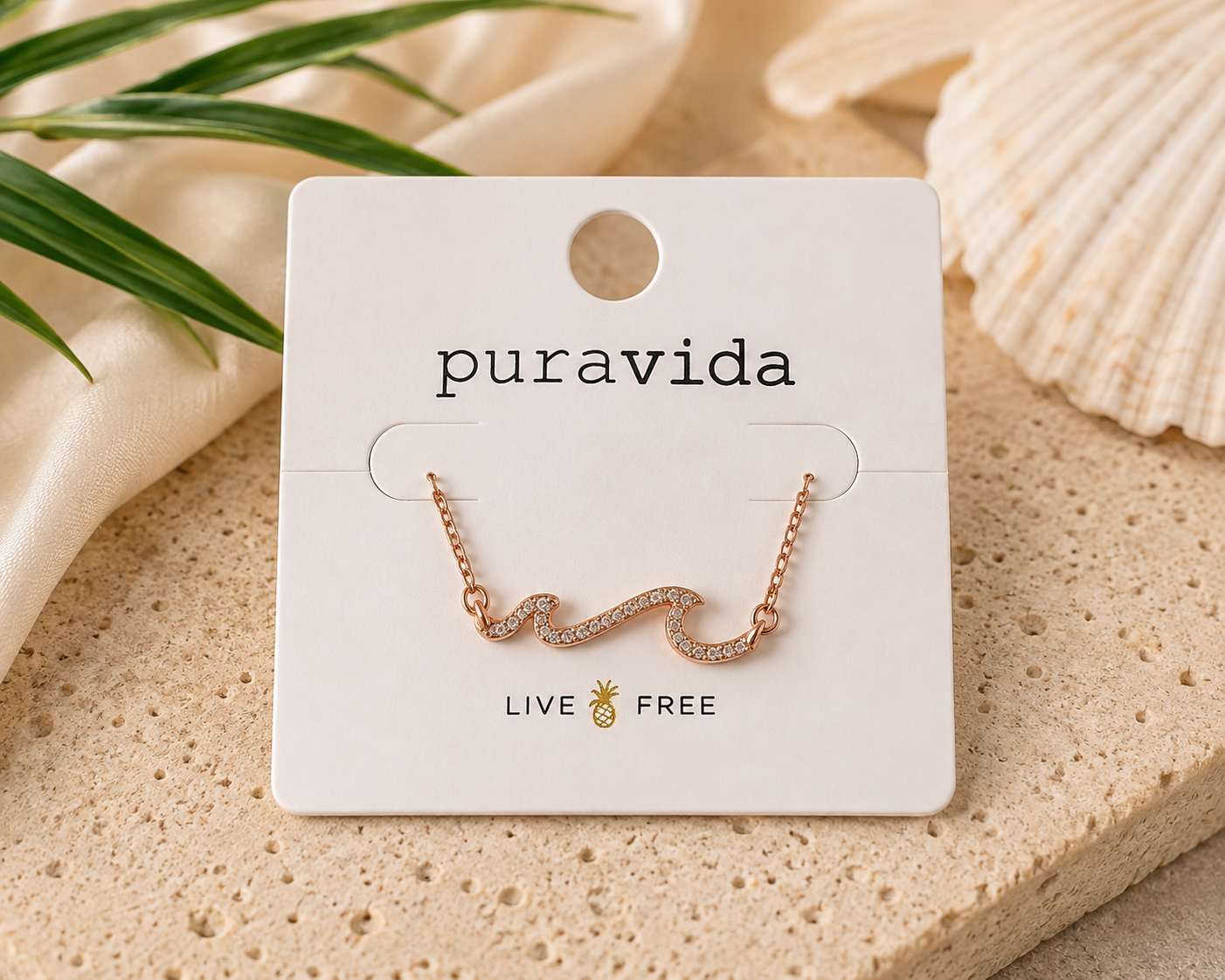 Authentic Pura Vida rose gold-tone necklace featuring a sparkling crystal wave pendant on a delicate chain, displayed on the original Pura Vida jewelry card, new and unworn.