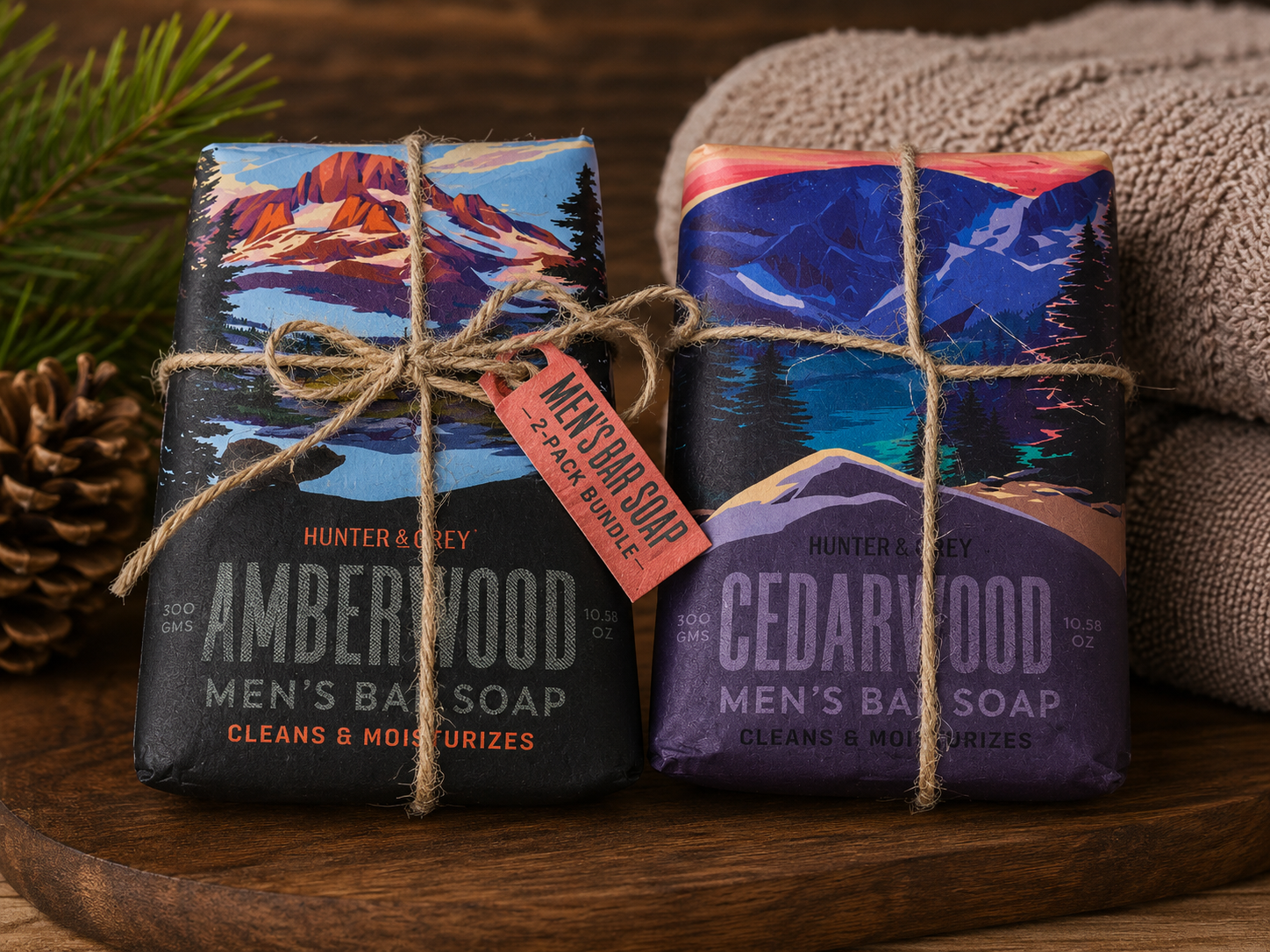 Hunter & Grey men's bar soap gift set featuring Amberwood and Cedarwood scented soap bars wrapped in rustic wilderness-themed packaging and tied with decorative twine.