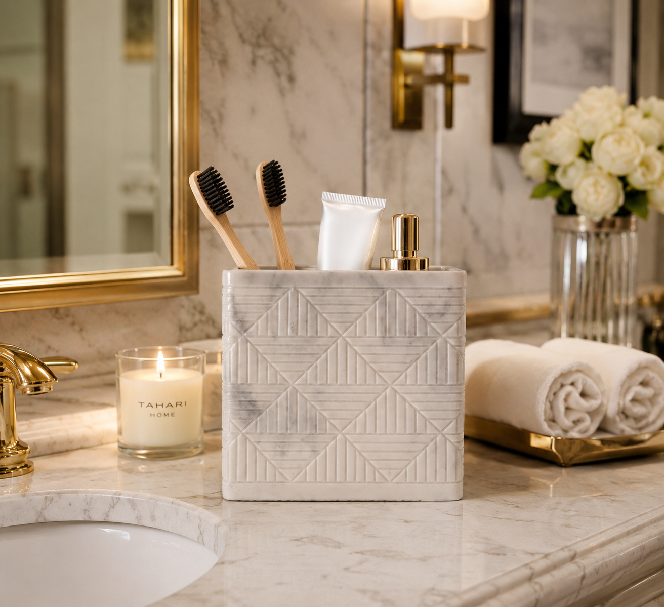 Tahari Home marble-look toothbrush holder featuring a white geometric textured design, displayed on a bathroom vanity holding toothbrushes and makeup brushes.