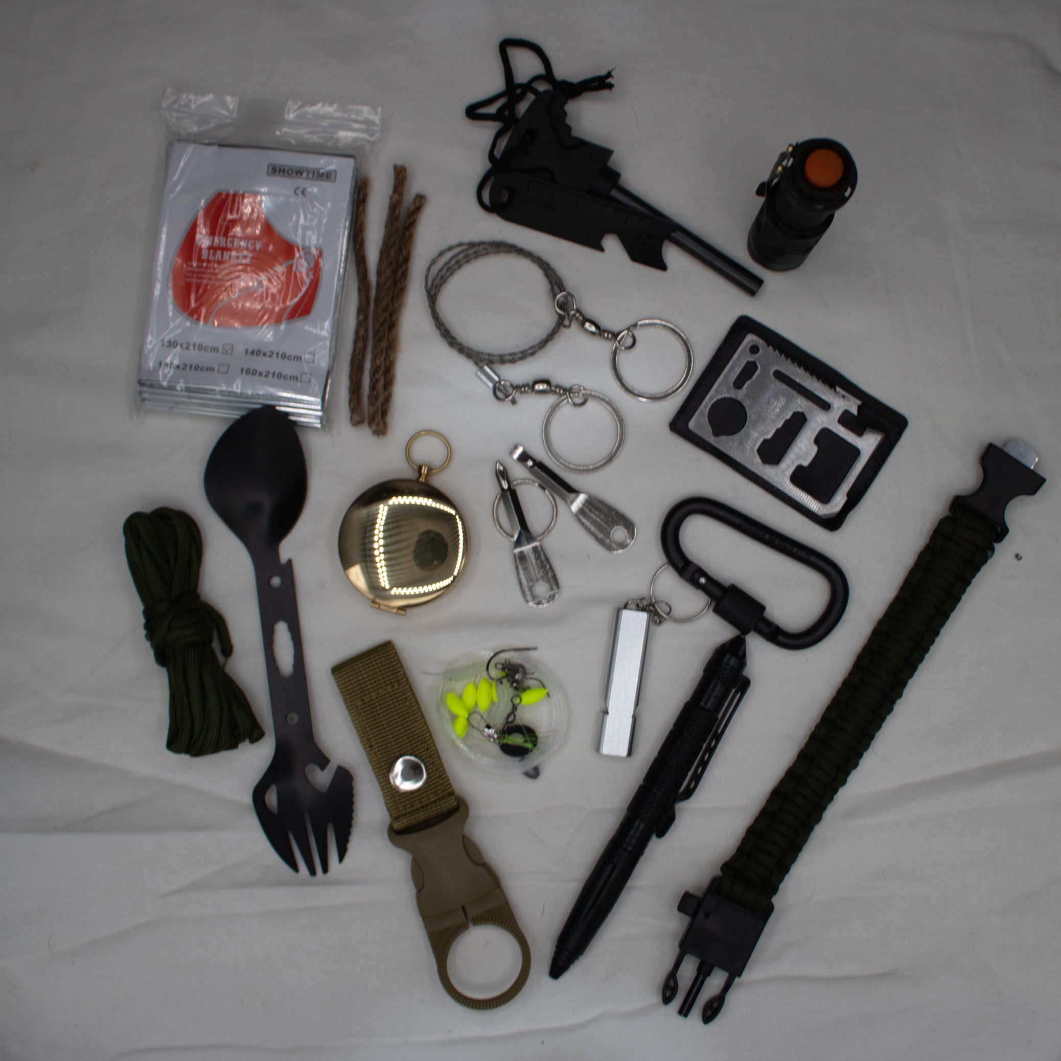 29-in-1 Survival Kit: Portable Outdoor Gear for Camping, Fishing & Adventuring - Perfect Christmas/Birthday Gift for Adventurers! A collection of outdoor survival tools including a flashlight, multi-tool, first aid kit, fishing kit, and other gear laid out on a grey surface.