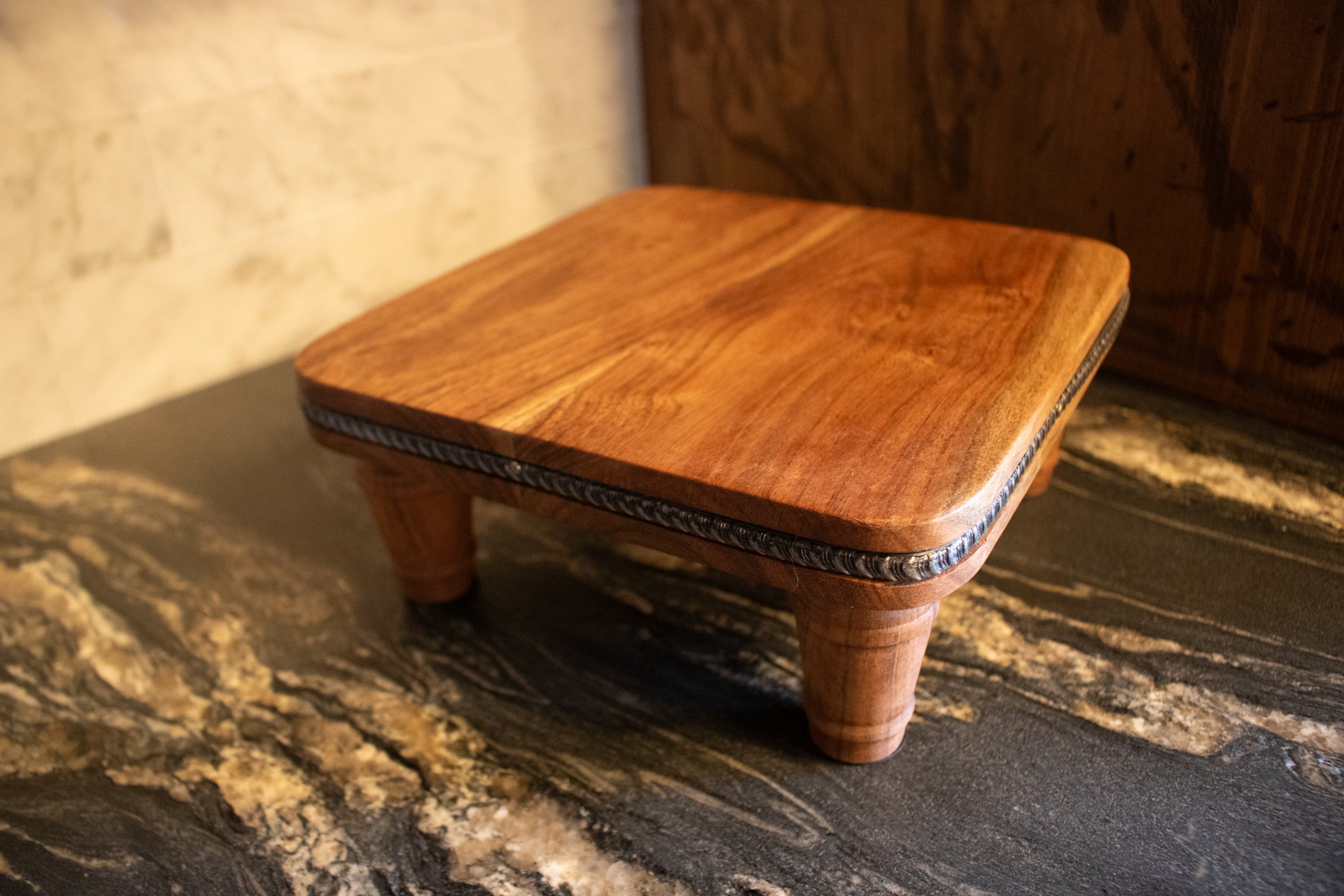 handcrafted solid wood pedestal display stand with turned legs and rich natural wood grain finish displayed on countertop