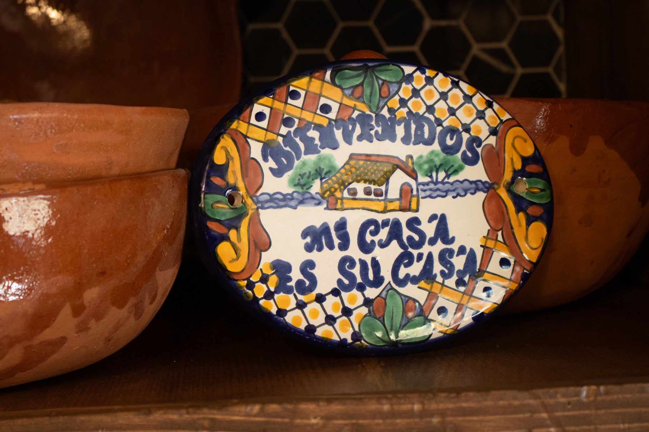 hand painted colorful ceramic welcome sign featuring Bienvenidos Mi Casa Es Su Casa text with traditional Mexican-inspired artwork and cottage scene