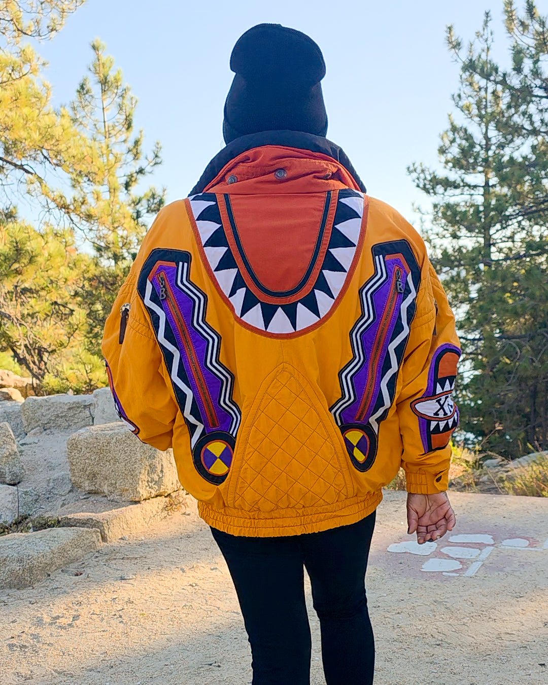Back view of the Bogner Goan Thylmann jacket worn outdoors among pine trees