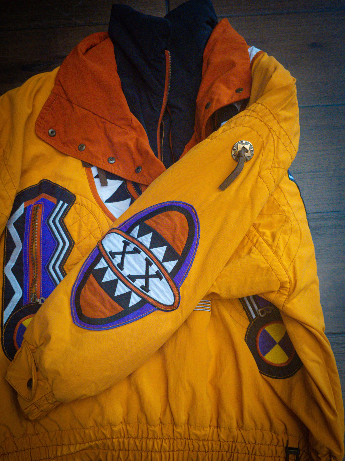 Close-up of the sleeve shield patch and concho snap tab on the Bogner jacket