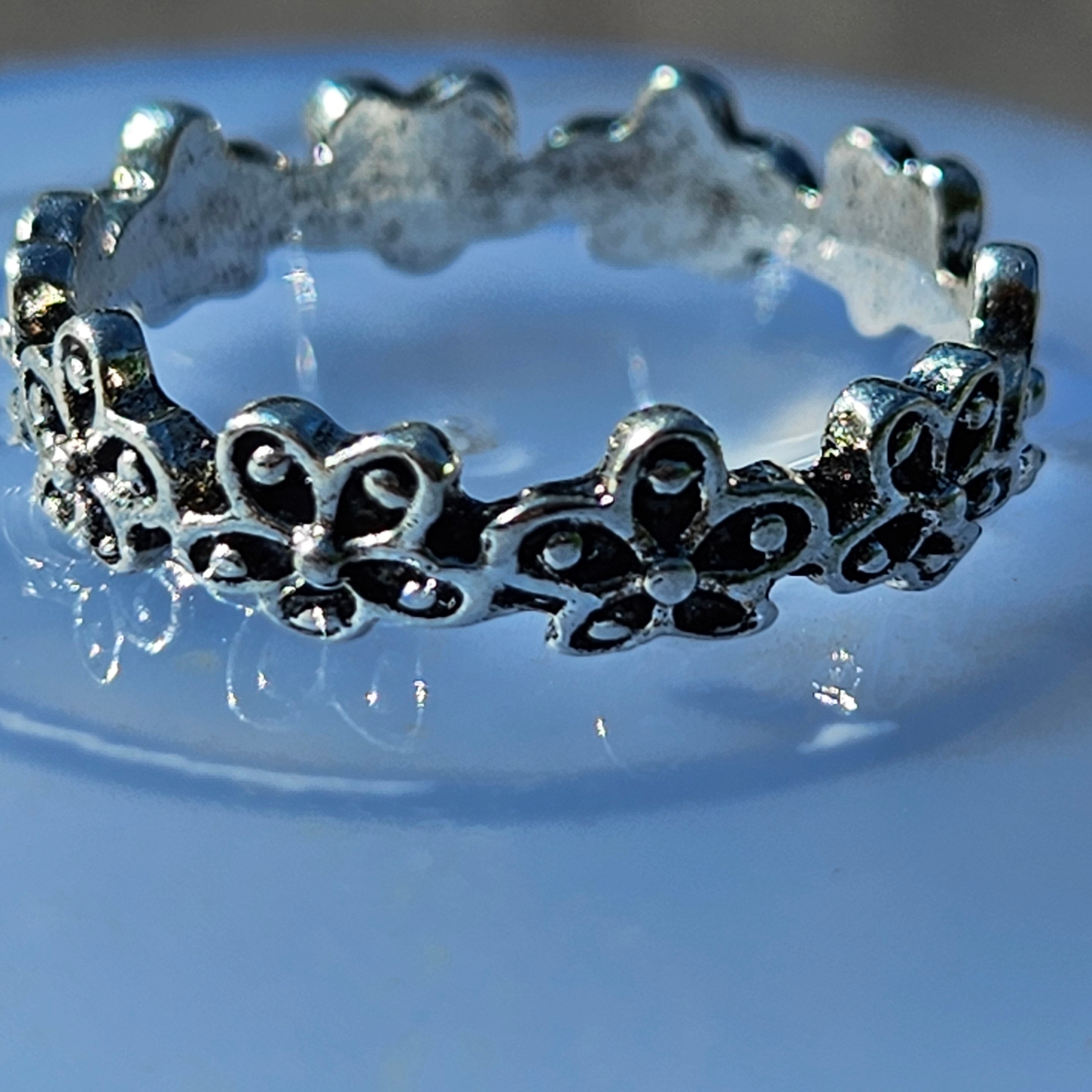 shiny silver plated floral band ring with repeating flower design and polished finish size 7