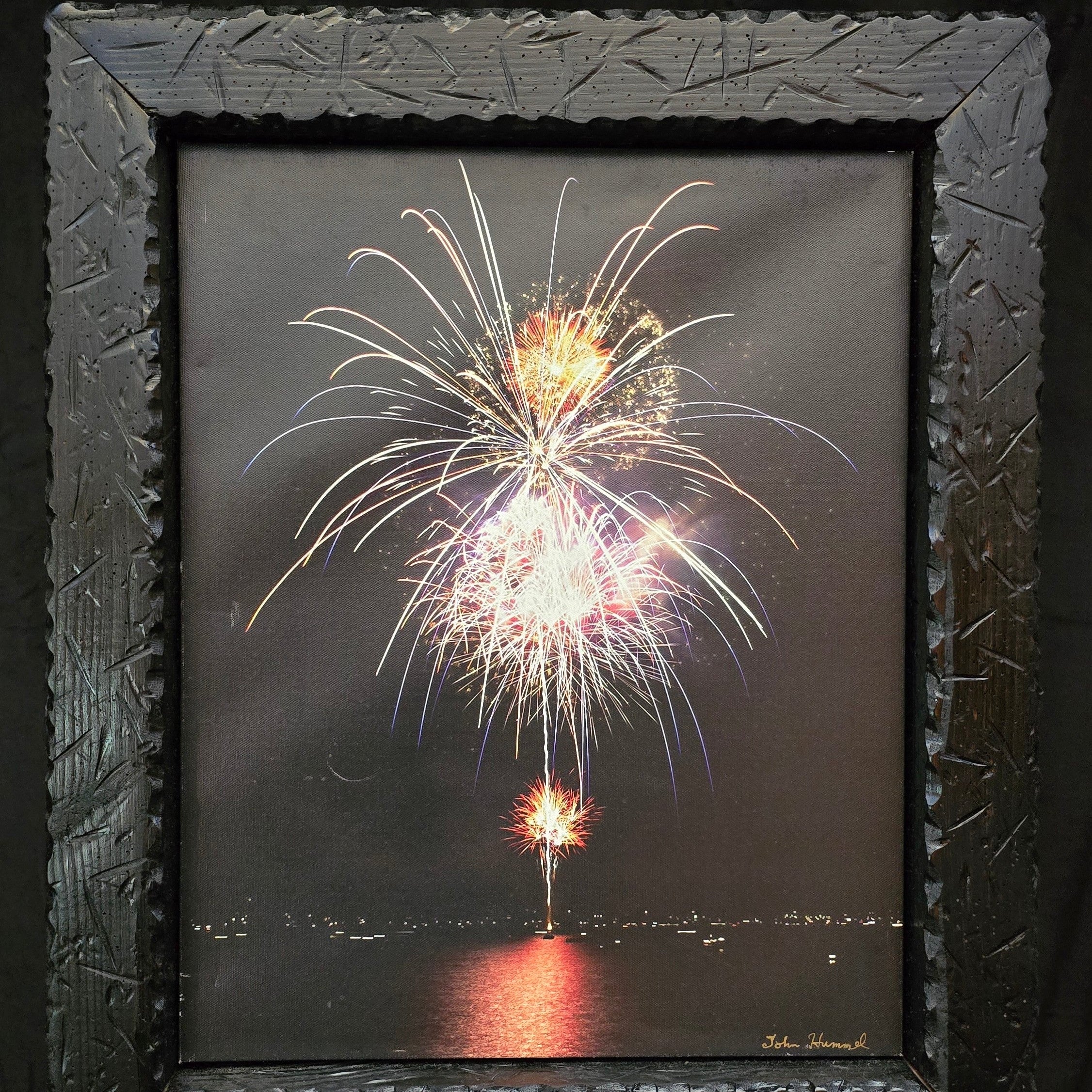 John Hummel framed fireworks canvas print featuring colorful nighttime fireworks reflected over water in rustic black textured wood frame