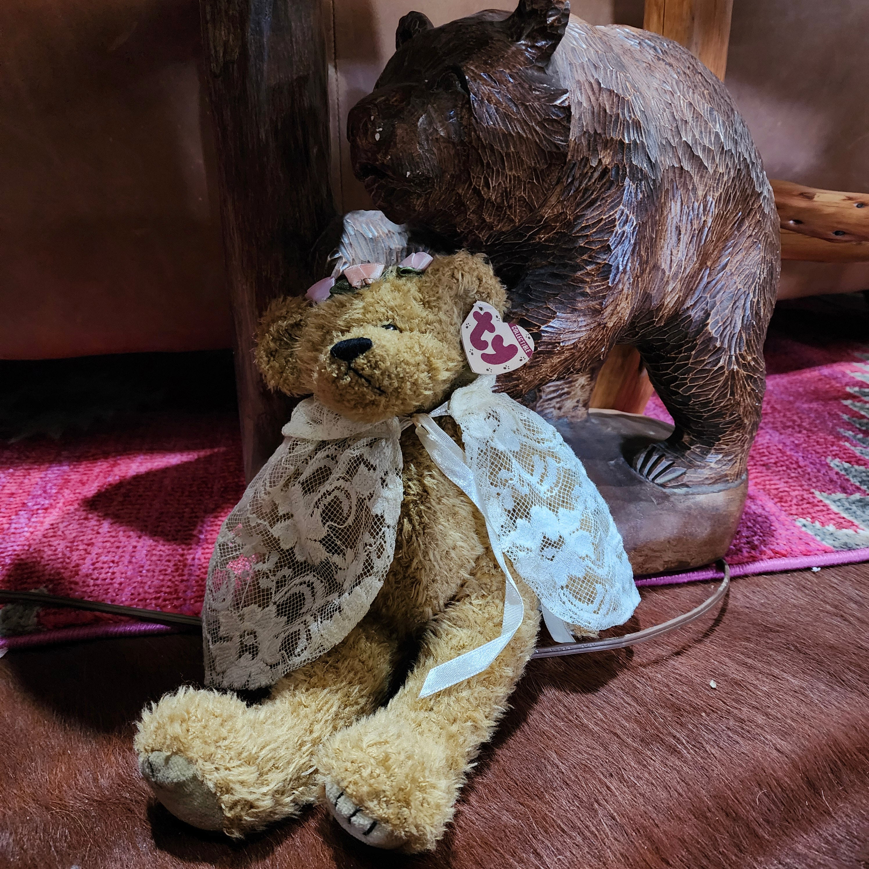 A plush toy bear, 'Eve the Bear' from Ty Beanie Babies collection, wearing a white and gold floral dress.
