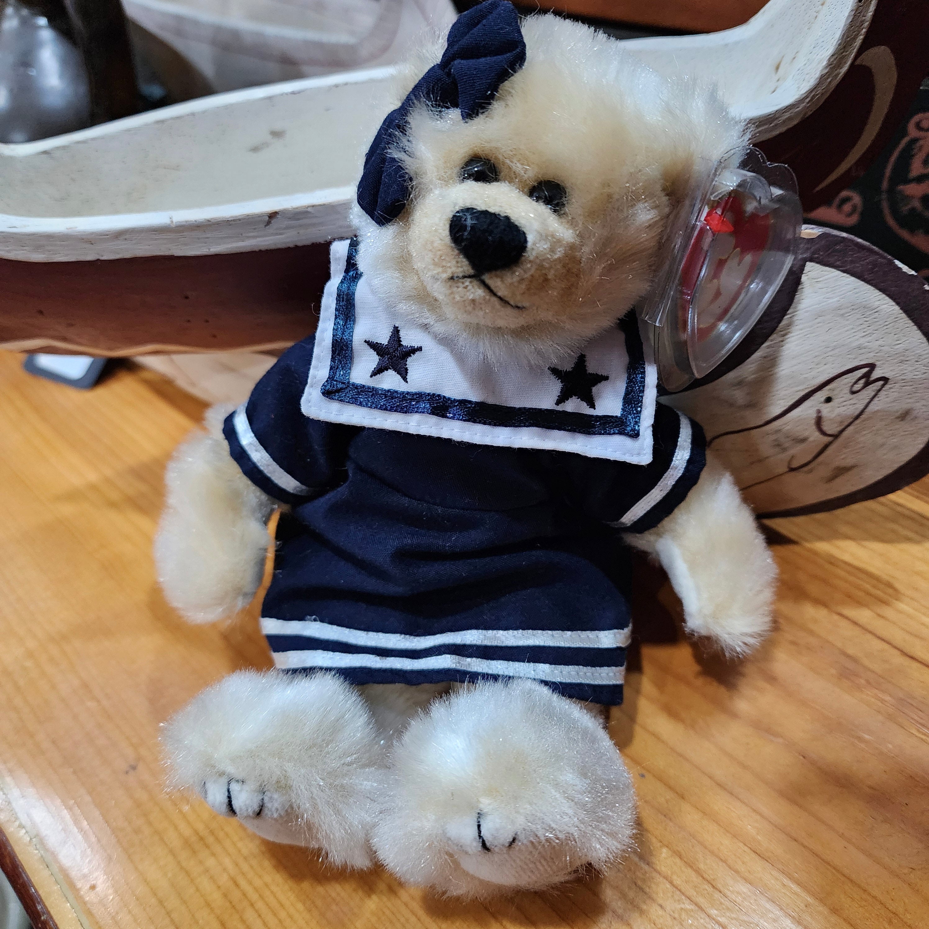 Ty Beanie Babies 'Breezy the Bear' dressed in a navy-blue outfit with a star pattern and a bow