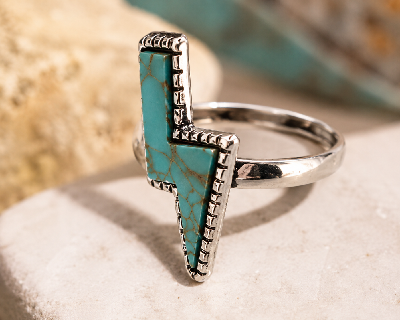 Silver-plated lightning bolt ring featuring a faux turquoise inlay and decorative border. Size 7 statement ring with Southwestern-inspired style and modern fashion appeal.