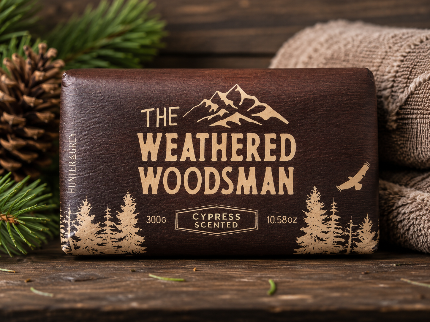 The Weathered Woodsman Cypress Scented plant-based soap bar in rustic packaging featuring woodland graphics, enriched with shea butter and vitamin E, weighing 10.58 oz (300g).