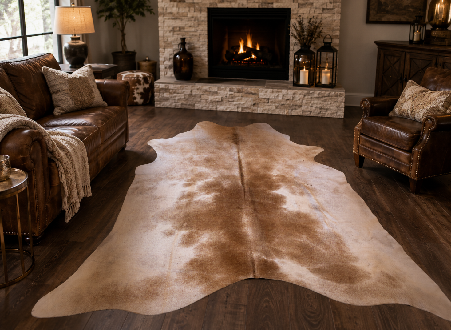 Neutral beige and light brown cowhide rug with natural markings displayed on a stone tile floor, ideal for Western, ranch, farmhouse, and rustic home décor.