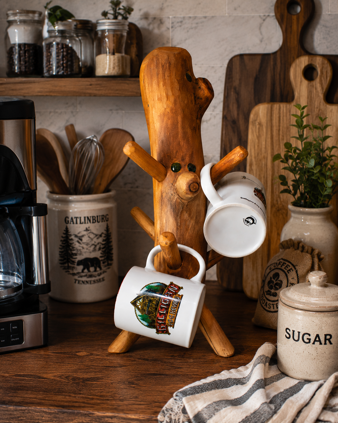 handcrafted rustic wooden mug holder with natural log style design and multiple peg arms displayed on countertop