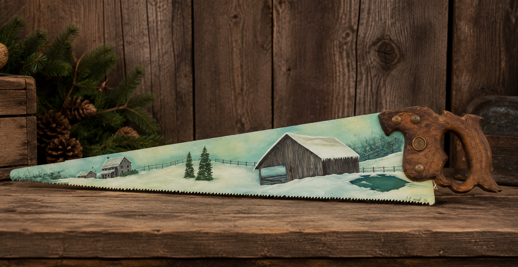Vintage hand-painted decorative saw blade signed by S. Corbin in 1983 featuring a snowy winter farm landscape with a barn, farmhouse, and evergreen trees on a 26-inch saw with original wooden handle.