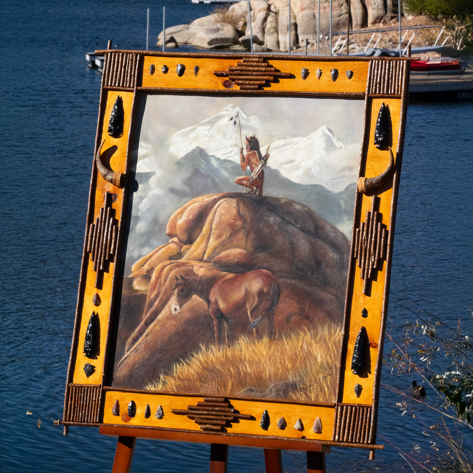original Shirley C Capra oil painting featuring Navajo Indian warrior and horse in handcrafted rustic wooden frame with arrowheads antlers feathers and natural stone accents