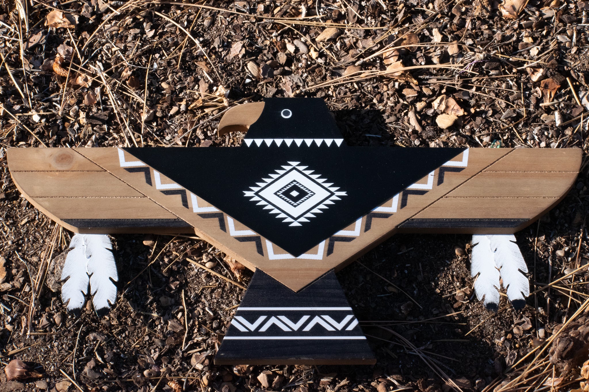 Lonestar Thunderbird wooden wall art featuring black, white, and natural wood geometric Southwestern patterns with decorative feather accents, measuring 18 inches wide by 10 inches high.