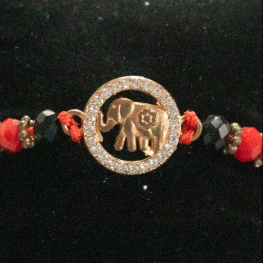 Red Braided Jute Cord Bracelet with Gold Colored Zirconia Elephant Charm