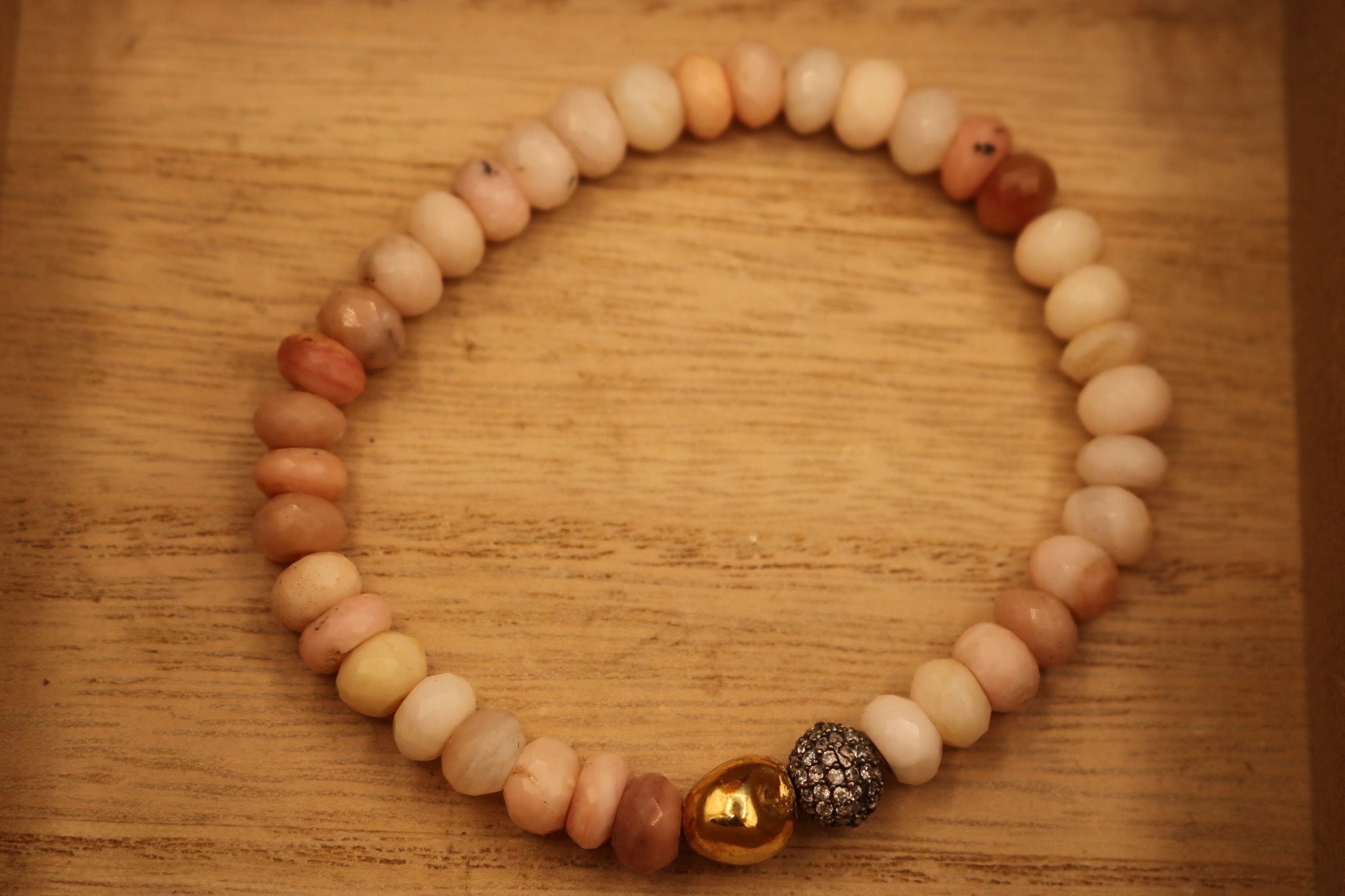 Calming Pink Opal Stone Bracelet Adorned with a Single Gold Bead and another Bead Embellished with Small Rhinestones.