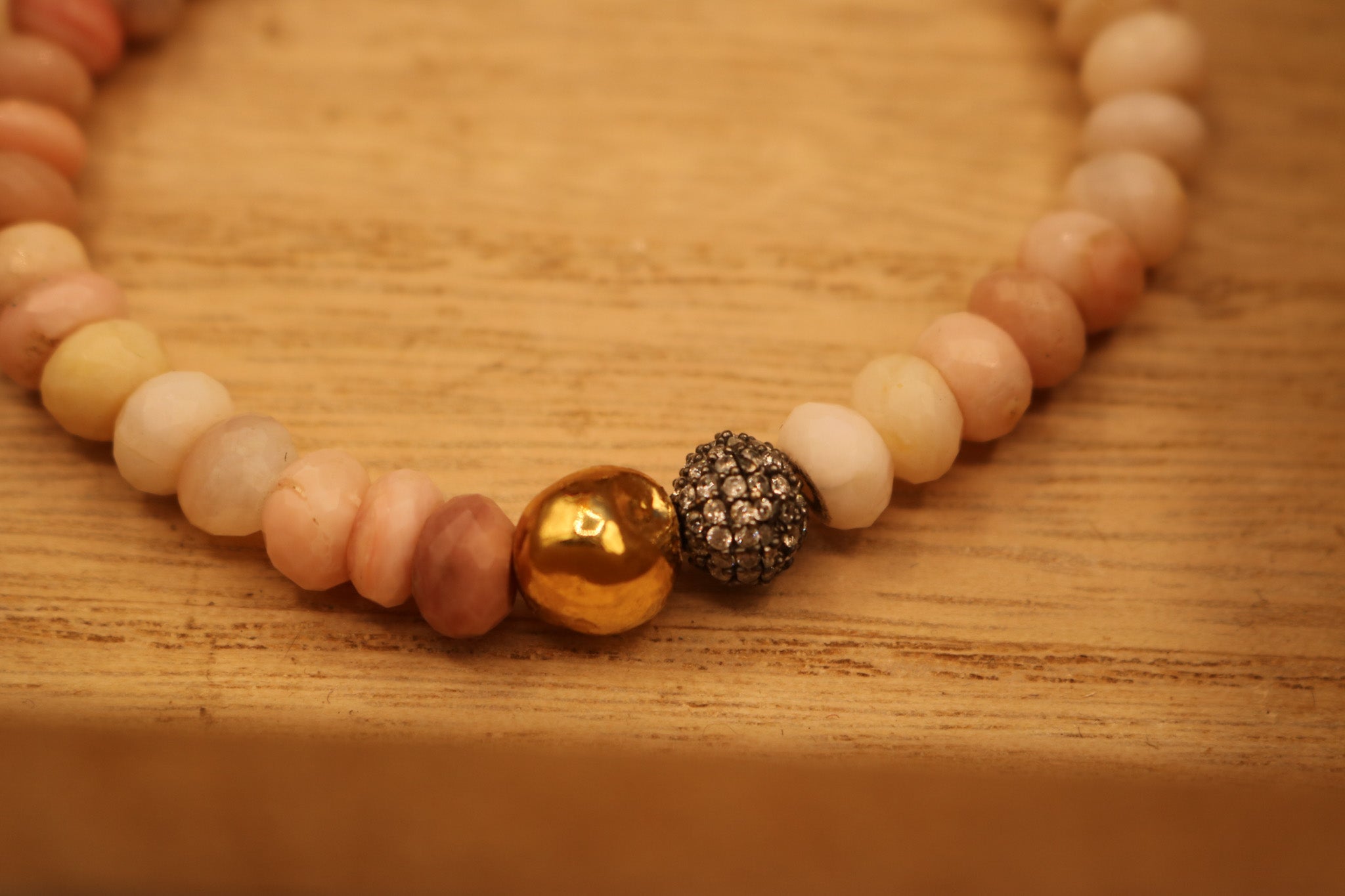 Calming Pink Opal Stone Bracelet Adorned with a Single Gold Bead and another Bead Embellished with Small Rhinestones.