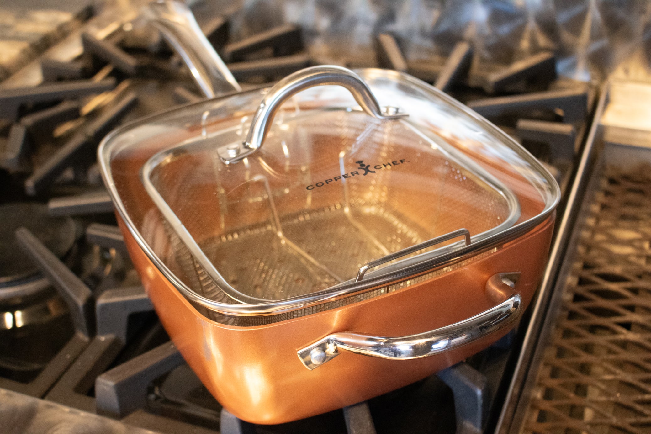 Copper Chef square nonstick copper pan with matching lid and removable stainless steel deep fry basket on stovetop