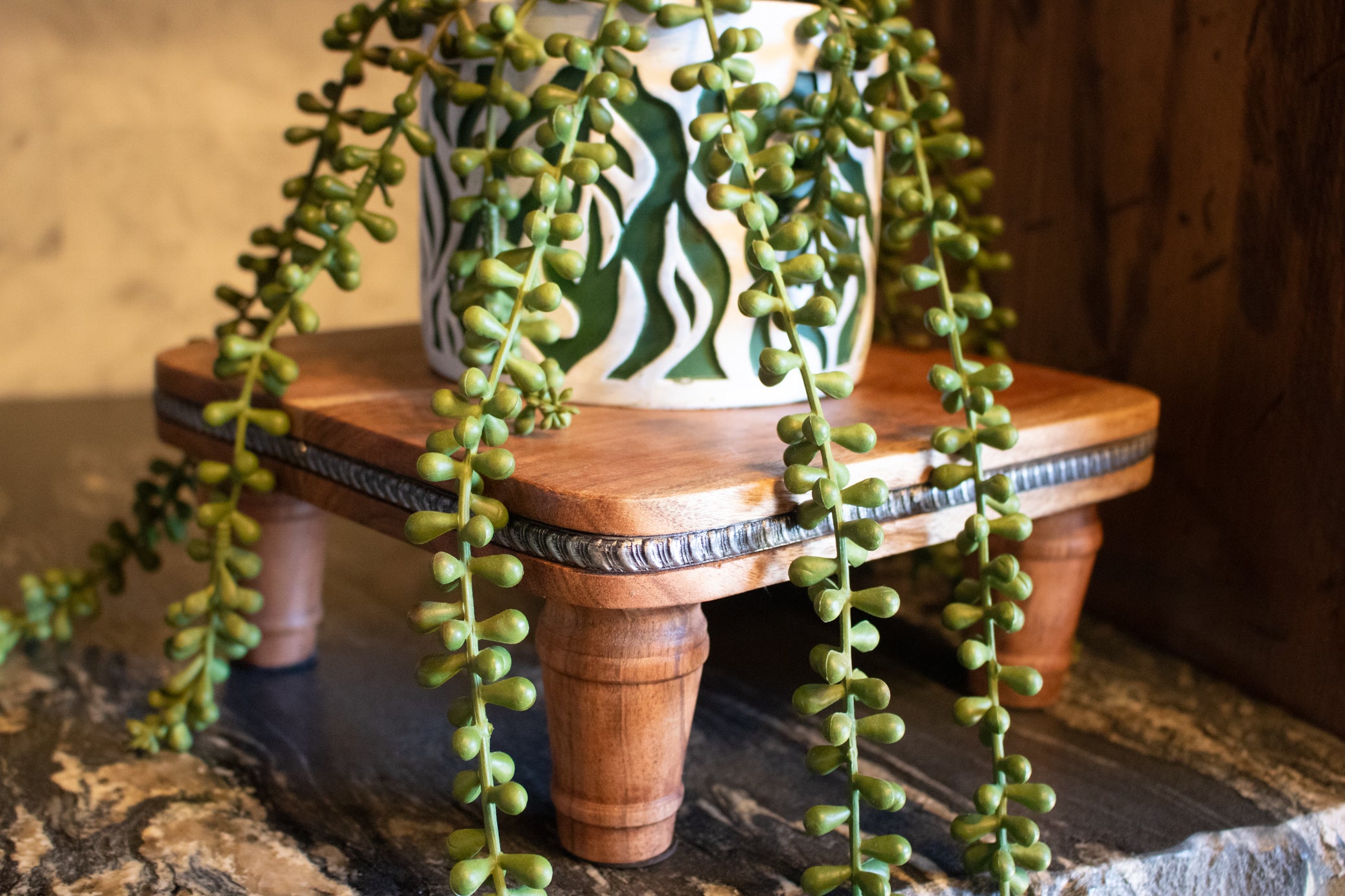 handcrafted solid wood pedestal display stand with turned legs and rich natural wood grain finish displayed on countertop