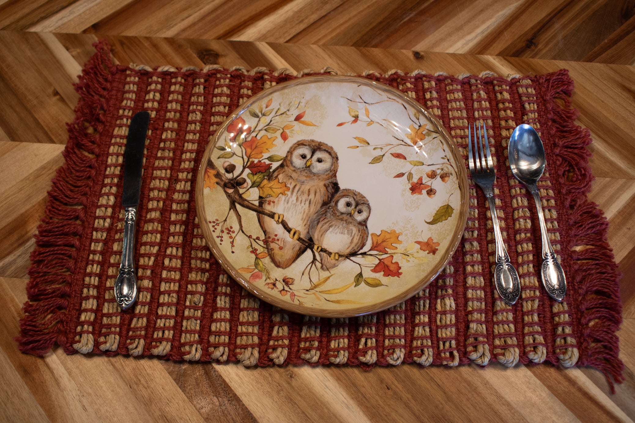 New set of seven handwoven rustic placemats featuring red and natural woven fibers with decorative fringe edges for farmhouse, cabin, and lodge-style dining tables.