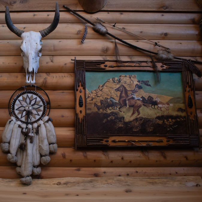 large framed western artwork titled War Indian on Bareback by Shirley C Capra featuring Native American rider on horseback in handcrafted rustic frame with arrowheads antlers and natural wood accents
