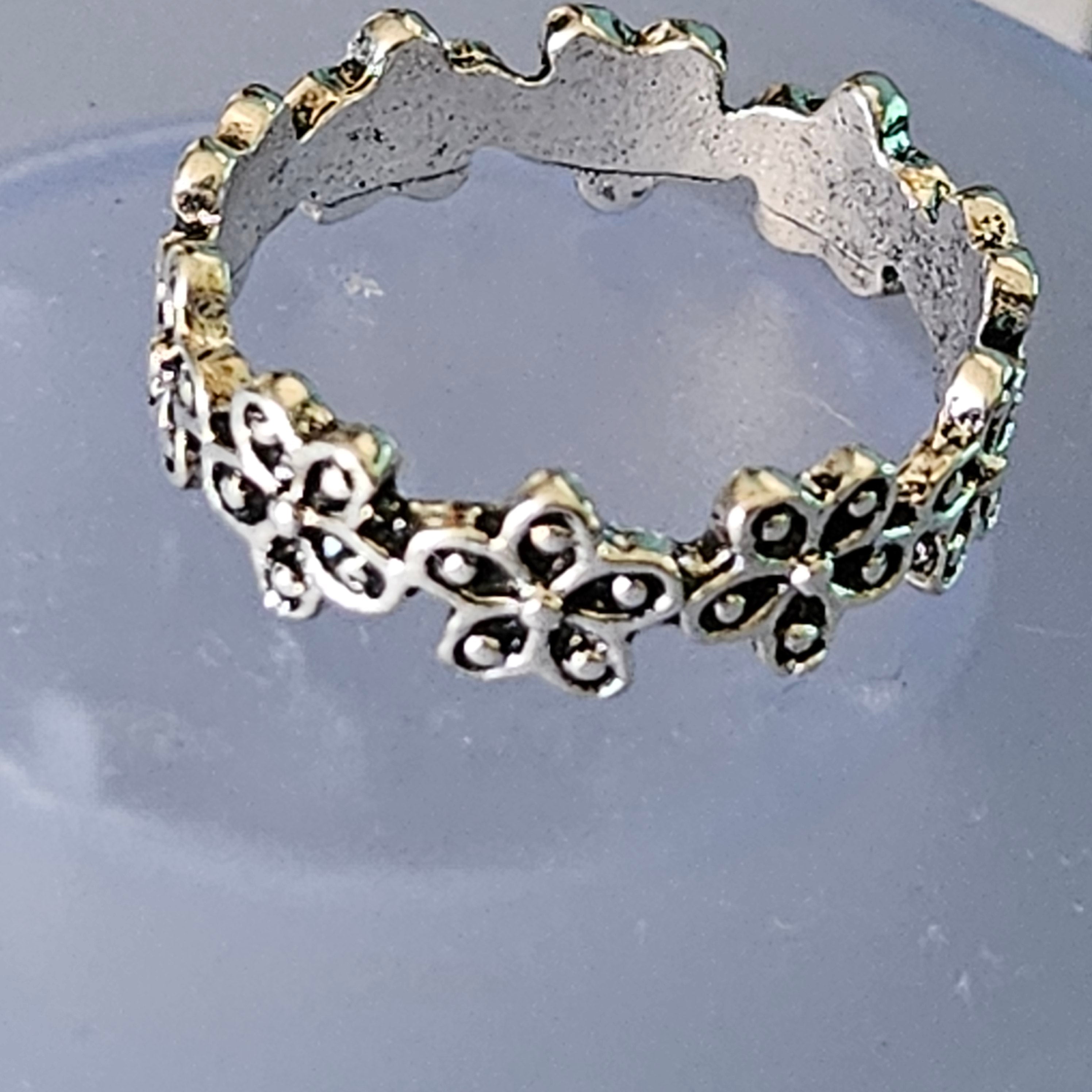shiny silver plated floral band ring with repeating flower design and polished finish size 7